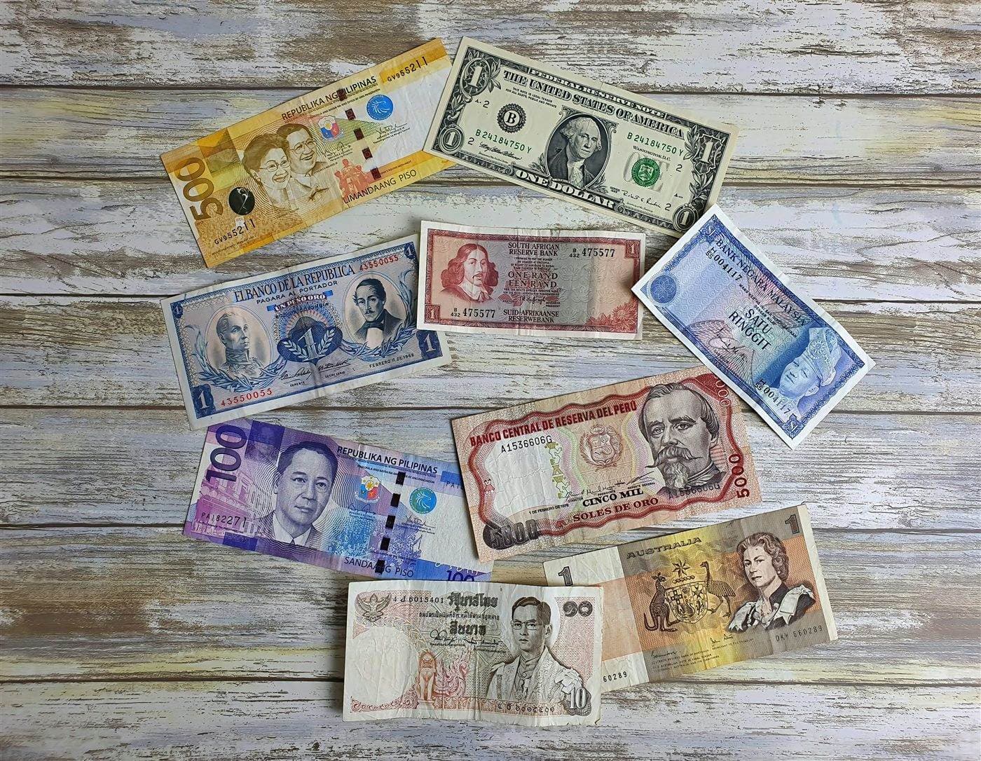 Des billets de banque de nombreux pays étalés sur une table